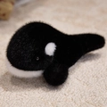 Peluche d'orque noir et blanc en fausse fourrure douce posée sur un tapis beige texturé - 18cm / Baleine