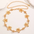 Close-up of golden bohemian metal chain belt with 3D floral links on white stones - Gold Flower Style