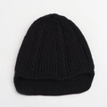 Detalle de la textura de punto de ochos negros y el patrón de canalé del gorro infantil - Negro