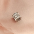 Macro shot of silver cylindrical spacer bead with square crystals on pink silk fabric - Steel Color 3-Layer Zircon