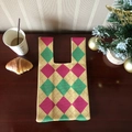 Pink and green argyle knit tote bag on a cozy wooden table with a coffee cup - Yellow Rhombus