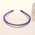 Detail van een paarse glitter haarband op een neutrale ondergrond met studiomeubilair - Donkerblauw