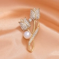 Elegante broche de tulipán dorado con diamantes y perla sobre fondo de seda melocotón - Dorado