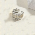 Anillo ajustable abierto con textura ondulada plateada sobre base de piedra decorativa - Plata a Rayas