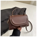 Close-up of a brown crossbody bag with contrast white stitching and top handle - Brown