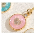 Vue macro de pendentifs mosaïque en nacre colorée avec cœur en zircon sur chaîne dorée - Rose
