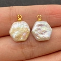 Pendente con perla barocca esagonale d'acqua dolce e gancio dorato mostrato sul dito - Esagono 13x16mm