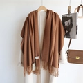 Detailed view of soft brown tassel scarf paired with a beige coat and fashion props - Latte / 200cm
