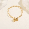 Close-up of gold stainless steel bracelet featuring textured links and heart pendant - Bracelet / Gold