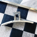 Close-up of a metallic silver hair claw clip on a textured black and white background - Long Arc Style (6)