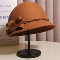Elegant dark brown wool cloche hat with a bow and faux fur pompom on a display stand - Size M (Adjustable) / Dark Camel