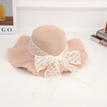 Pink straw sun hat featuring a white lace bow and wide wavy brim for summer beach vacation - Lace Diamond Pink