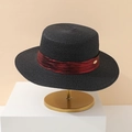 Detail of flat top straw hat featuring a chic red ribbon and golden oval metal logo - 55-58cm / Black With Small Metal Tag