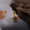 Macro view of a S925 silver gold-plated pendant with amber gemstone on a dark stone - Natural Citrine Round Pendant Gold