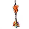 Macro view of handmade woven rope holding a raw orange healing crystal with chakra stones - Orange Calcite