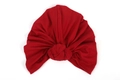 Detailed view of red knitted turban hat featuring central knot and pleated texture - Burgundy