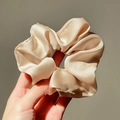 Vista dettagliata dell'elastico per capelli in raso champagne con trama liscia - Oro rosa
