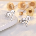 Minimalist hollow heart stud earrings in 18K gold plated silver on decorative background - White Gold