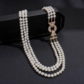 Vista dettagliata della collana di perle a tre strati con eleganti ganci dorati - Collana-Bianco