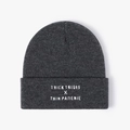 Close-up of dark grey knitted beanie featuring white thick thighs thin patience embroidery - One Size / Dark Gray