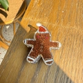 Macro detail of gingerbread man hair claw clip made of brown glitter acrylic on wood - Gingerbread Man