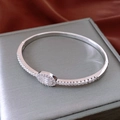 Close-up of silver oval bangle with pave-set zircon detail on a silk background - Platinum Plated Oval Hinge Style / Silver