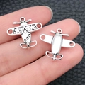 Silberne Flugzeuganhänger aus Legierung für DIY-Schmuck auf einem Finger gezeigt - Flugzeug 18x19mm / Tibetsilber