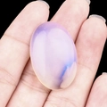 Oval opal stone with blue sand texture for jewelry DIY making held by hand - Opal (Synthetic)