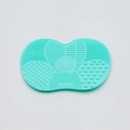 Detail of teal silicone makeup brush cleaner mat with various cleaning textures and patterns - Small Apple Shape / Green