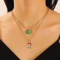Close-up of double-layered Christmas necklace with green bell and festive wreath charms - Christmas Wreath (N-1120) / Gold