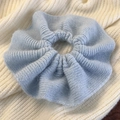 Detaillierte Nahaufnahme der weichen blauen Stricktextur und gerafftem Haar-Scrunchie - Blau