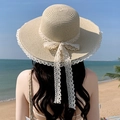 Beige wide brim straw sun hat with white lace bow on a sandy beach background - Large Brim Binding Beige