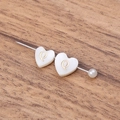Handmade freshwater shell heart bead with gold letter Q and a white pearl on wood background - Letter Q