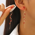 Long tassel spiral earrings in gold finish with red gemstones worn by a model - Gold with Red Zircon Style (9457)