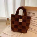 Close-up of checkered lamb wool bucket bag with woven texture and premium white fabric label - Coffee