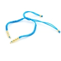 Close-up of blue braided cord bracelet with adjustable closure and gold metal beads - Blue