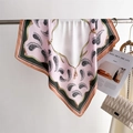 Dettaglio di un foulard in seta rosa con motivo paisley appeso all'asta di metallo - Taglia unica / Bianco