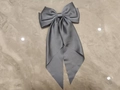 Elegant grey satin bow hair clip with long streamers on a marble texture surface - Gray