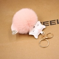 Detailed close-up of pink fluffy fox fur pompom keychain with golden metal clasp hardware - Pink