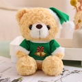 Close-up of a teddy bear in a green Christmas sweater with festive holiday patterns - Green T-shirt Style (Light Brown Bear)