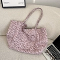 Sac fourre-tout en daim à motif léopard rose avec doubles bretelles sur un canapé - Rose