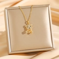Squisita collana con orsetto dorato con cristalli scintillanti su sfondo di lussuosa seta champagne - Orso 3D Oro