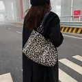 Bolso tote grande de lona con estampado de leopardo, correas de cuero y aros dorados - Negro