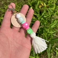 Detalle de llavero con cuentas de silicona verdes, colgante de madera y borla de algodón blanco - Blanco Y Verde HBBD