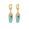 Detail van vergulde oorringen met blauwe emaille slippers hangers en boze oog motief - Blauw