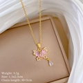 Collana a farfalla dorata con cristalli rosa e ciondolo a goccia su sfondo di seta - Stile Farfalla Rosa e Goccia d'Acqua (E546)