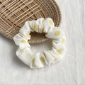 Detailed macro view of a white chiffon scrunchie with yellow polka dots on a wooden tray - White with Yellow Polka Dots