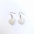 Macro detail of heart-shaped white quartz earrings with silver hooks on white background - White Jade