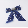 Dettaglio macro del fermaglio a fiocco in velluto blu reale con strass e cristalli - Velluto blu reale con accenti di strass