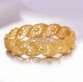 Detailed view of hollow floral patterns on a vintage golden wavy bangle for women - Twist Flower